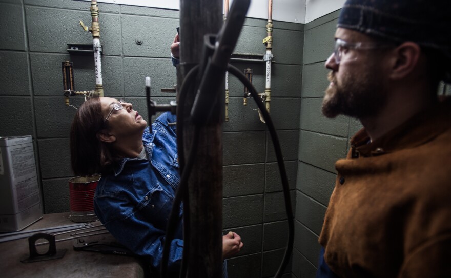 Spartanburg Community College welding instructor Teresa Elder (left) grades Harris during class.