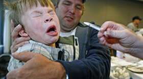 Spencer Whatcott pulls away after receiving the H1N1 nasal spray vaccine while his father holds him at the Utah County Health Department in Provo, Utah, in late October.
