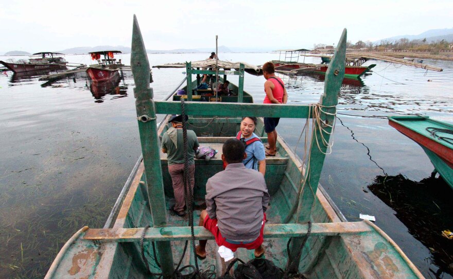 Fishermen head to Taal Volcano Island to rescue their horses and other livestock in Talisay, Batangas, on Sunday.