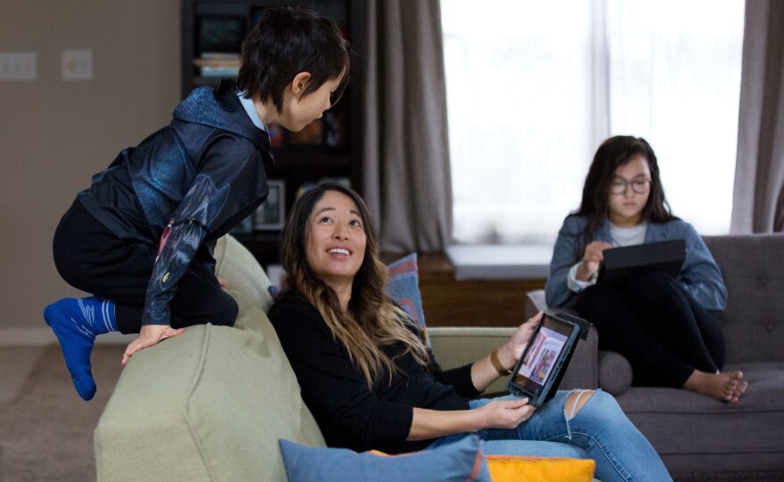 Chen's son Campbell climbs on the couch as he becomes restless while doing schoolwork at home.