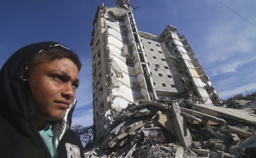 Palestinians walk by a residential building destroyed in an Israeli strike in Rafah, Gaza Strip, on March 9.