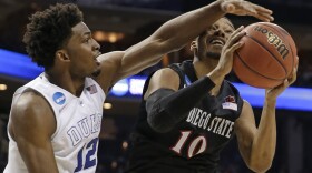 Duke's Justise Winslow (12) blocks a shot by San Diego State's Aqeel Quinn (10) during the second half of an NCAA tournament college basketball game in the Round of 32 in Charlotte, N.C., March 22, 2015. Duke won 68-49. 