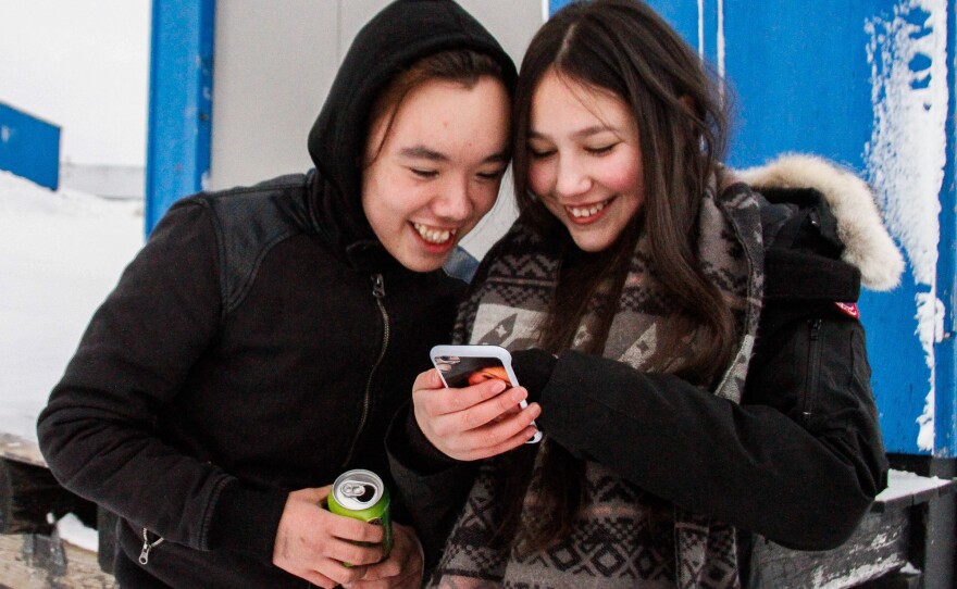 Eino Taunajik and Kamilla Larsen watch a music video during a break from the suicide prevention course in Tasiilaq.