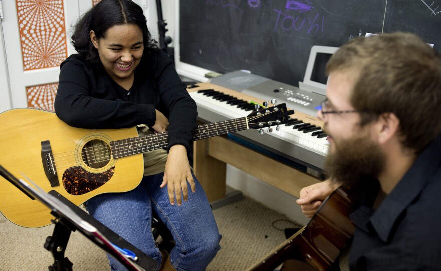Tanzania Cantrell, 13, of Saginaw, Mich. jokes with her guitar instructor, Ryan Fitzgerald, during a lesson at Major Chords for Minors.