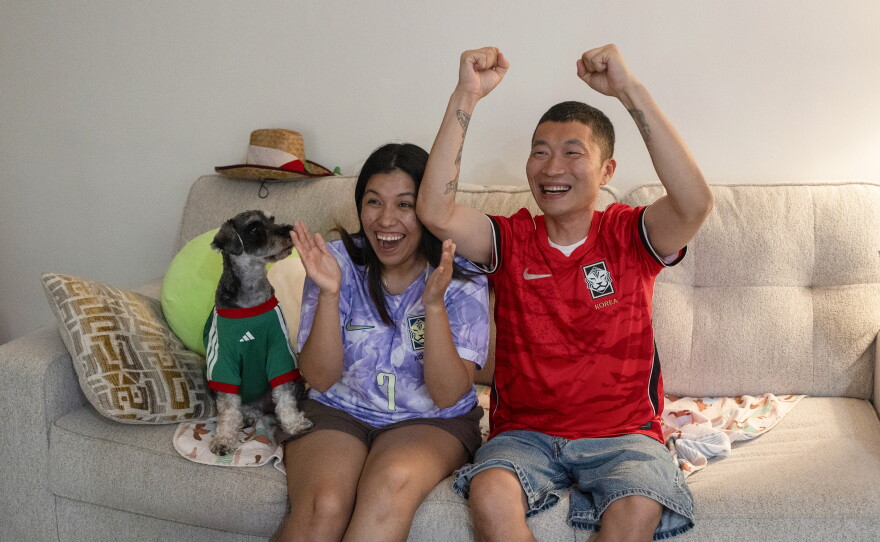 Mirella Vargas and her husband, Bonyub Koo, watch a soccer match with their dog in Los Angeles on June 11.