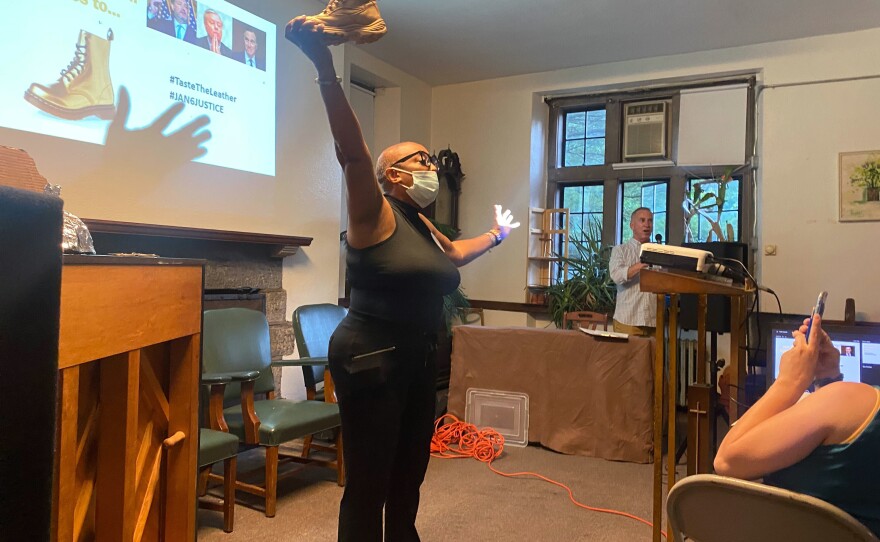 Tonya Bah holds up a "Golden Boot" trophy, part of a satirical awards ceremony held at a watch party in Philadelphia for Thursday's hearing of the House select committee investigating the Jan. 6 attack on the U.S. Capitol.