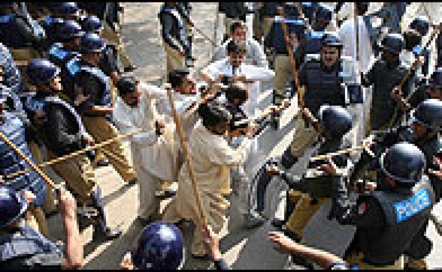 Pakistani riot police beat a lawyer during a protest in Lahore on Nov. 5.