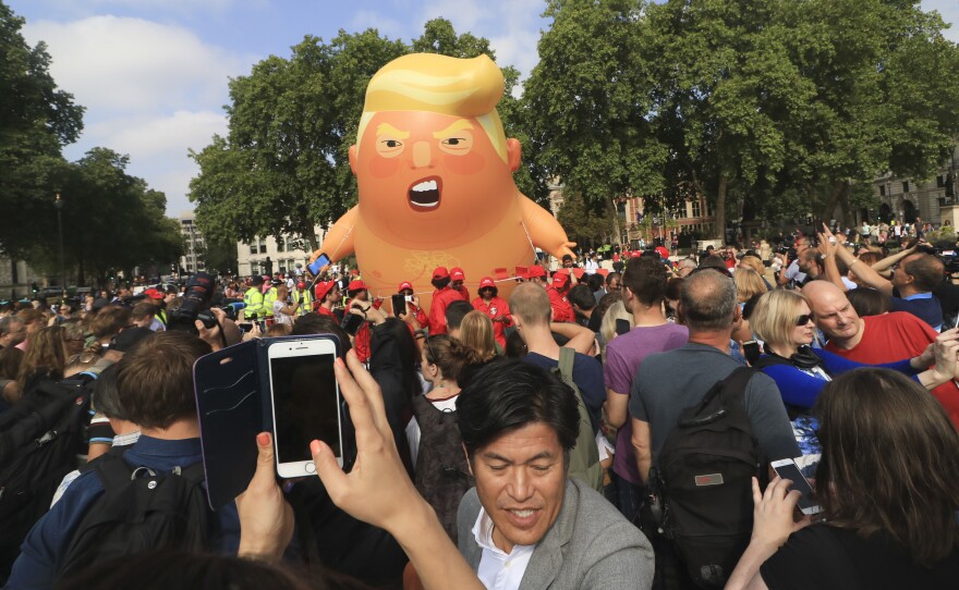 A protest against President Trump in London's Parliament Square includes a giant balloon of "Trump Baby" in a diaper on Friday. It flew high above the statutes of prominent historical figures including Winston Churchill, Mahatma Gandhi and Millicent Fawcett.