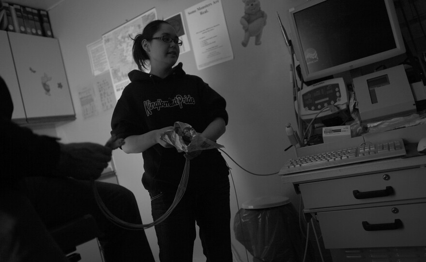 Octavia Wilson looks through supplies in a tele-medicine cart in Wales, Alaska. Patients can see a therapist or have an exam via satellite-linked video, which is helping rural veterans in Alaska, where weather and distance can be extreme.