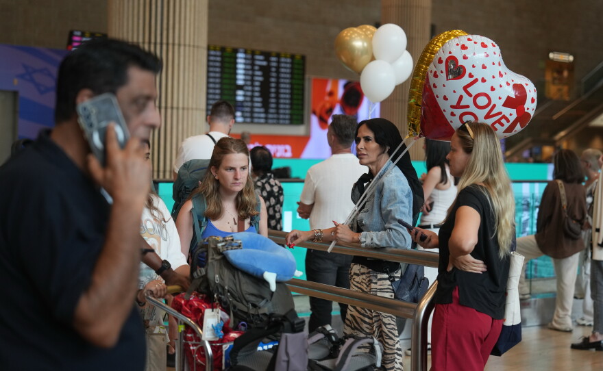 Holding balloons people wait for the arrival of passengers at Ben Gurion International Airport, near Tel Aviv, Israel, Wednesday.