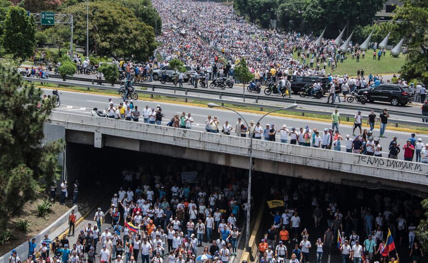 Demonstrators clog a Caracas highway on Wednesday, shouting their resistance to Maduro. The president's push to tighten his power has helped trigger deadly unrest in Venezuela.