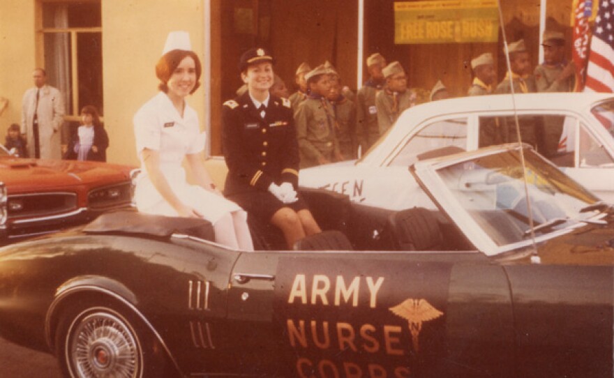 Diane Evans, sits on the back of a car with a sign that reads "Army Nurse Corps, 1968.