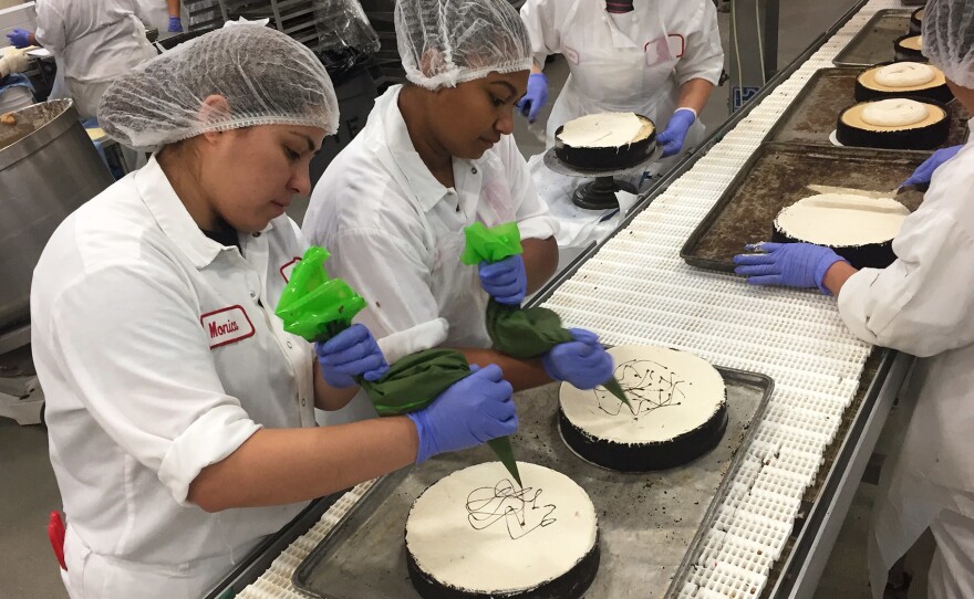 Employees hand-finish cheesecakes on the production line at Eli's in Chicago.