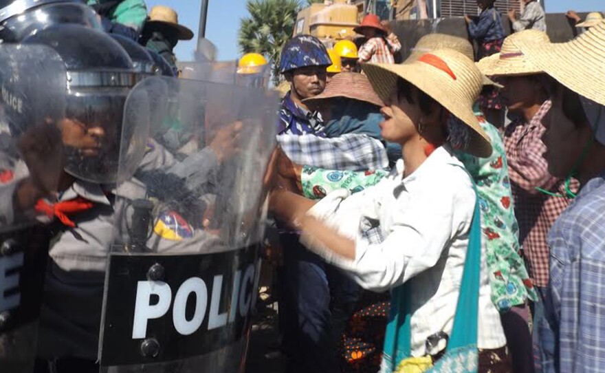 Farmers confront riot police at the site of the Letpadaung copper mine in northwestern Myanmar on Monday. A woman was fatally shot during a crackdown on protesters at the Chinese-backed copper mine.