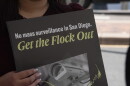 A protester holds a sign at a press conference announcing a lawsuit over the city of San Diego's use of Automated License Plate Reader technology on Sept. 30, 2026.
