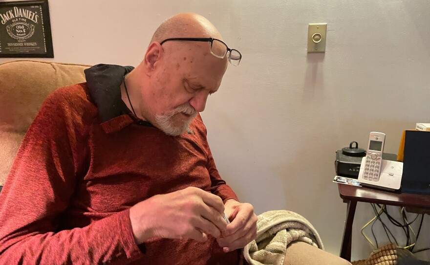 Kim Hilton, who has Type 2 diabetes, checks his blood sugar while friends sort through his belongings on the day he moved out of his house because of a rent hike.