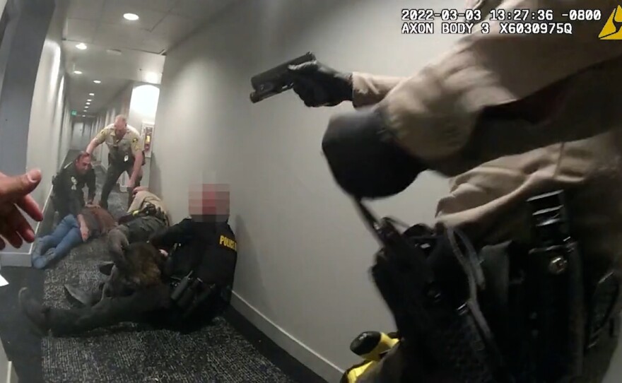 A freeze frame from a deputy's body-worn camera is shown at the moment deputies and police officers opened fire on Yan Li in her condo hallway on March 3, 2022.