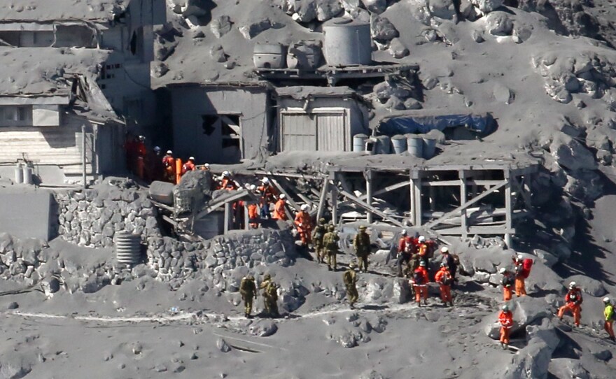 Rescue workers and Self Defense Force soldiers searching for missing climbers and survivors among ash-covered mountain cottages on the top of Mount Ontake in central Japan.