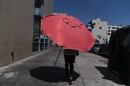 A woman walks with a beach umbrella in Los Angeles, Wednesday, Aug. 31, 2022. Excessive-heat warnings expanded to all of Southern California and northward into the Central Valley on Wednesday, and were predicted to spread into Northern California later in the week.
