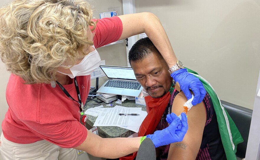 During half-time at a Mexico-USA match in Denver, Oscar Filipe Sanchez receives the Johnson & Johnson COVID-19 vaccination inside a mobile health clinic parked outside Empower Field at Mile High.