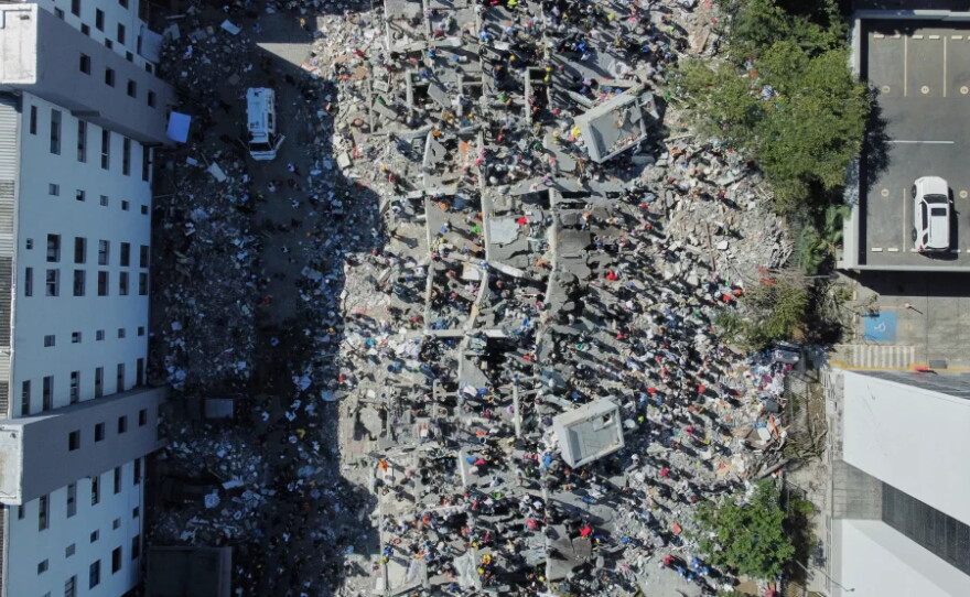 Residents and rescue workers search through the rubble after an earthquake struck Cali, Colombia, Monday, Aug. 10, 2026.