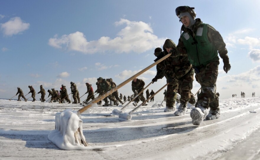 USS Ronald Reagan crew members scrub the flight deck as a radiation countermeasure, March 2011.