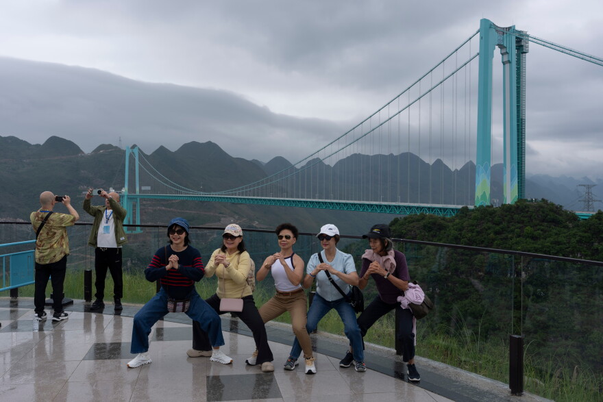 Tourists pose for photos near the Huajiang Grand Canyon Bridge, considered to be the world's highest bridge, in Anshun in southwestern China's Guizhou province on Friday, May 29, 2026.