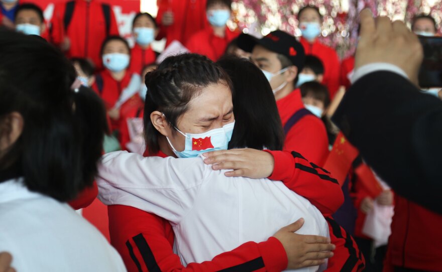 Health workers from Tongji Hospital in Wuhan, China, share an emotional embrace with their peers from a hospital in Jilin province at the Tianhe Airport. Colleagues who worked on the front lines together bid farewell as Wuhan lifted its coronavirus lockdown in April.