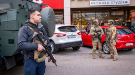 Police officers are seen at the site where a gunman killed at least six people in the streets before being shot dead by police, in Kyiv, Ukraine, Saturday, April 18, 2026.