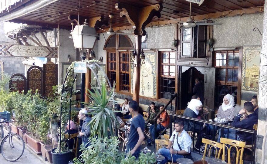 A cafe does a brisk business in Damascus. The city has suffered less damage and the economy still functions compared with many other parts of the ravaged counry.