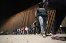 A group of migrants, mostly from Cuba, line up to board a bus after crossing the border from Mexico and surrendering to authorities to apply for asylum on Thursday, Nov. 3, 2022, near Yuma, Arizona.