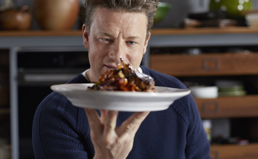 Chef and host Jamie Oliver holds a plate of his succulent sticky kickin' chicken wings. 