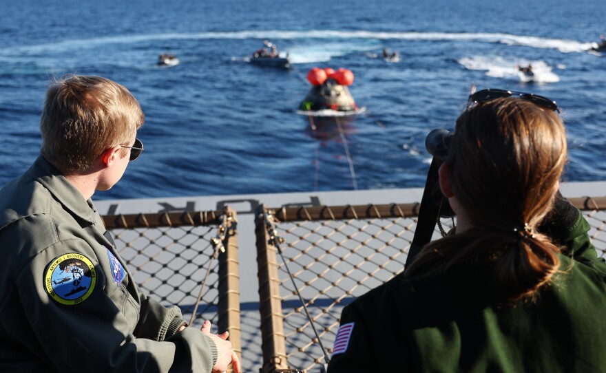 NASA recovery team members watch as NASA's Orion Capsule approaches after splashing down in the Pacific Ocean, west of Baja, Calif., following a successful uncrewed Artemis I Moon Mission on December 11, 2022.