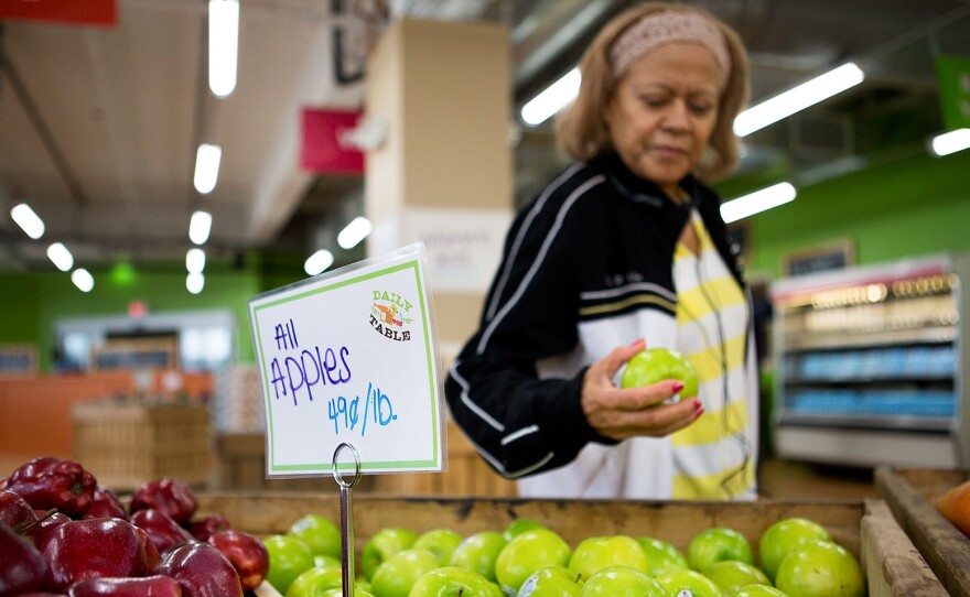 Noemi Sosa looks at an apple as she shops at Daily Table, the first nonprofit supermarket. It's located in Dorchester, Mass.