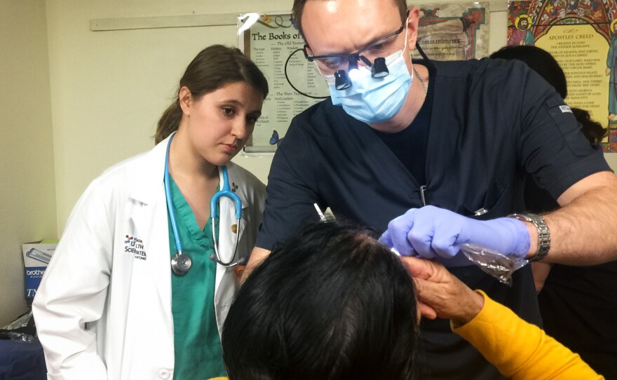 Third-year dental student Alex Dolbik checks the oral health of a patient at the Refugee Health Clinic in San Antonio.