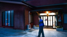 Shuichi Kanno, 79, walks in front of his home at dusk. Kanno has been dealing with hordes of macaque monkeys in his neighborhood in Japan. They frequently wake him up as they climb over his roof in the early morning hours.