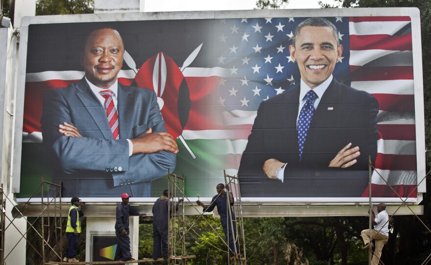 Workers finish installing a billboard showing Kenya's President Uhuru Kenyatta and President Barack Obama in downtown Nairobi a day before Obama's visit.