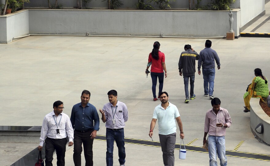 Wipro Ltd. employees walk inside the company's compound in January during a break at their headquarters in Bangalore, India. Top Indian IT companies are in the crosshairs of proposed changes to U.S. H-1B visas, including an executive order President Trump is expected to sign Tuesday.