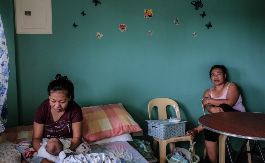 Mylene Madawat, 24, holds her newborn son. Her mother, Minda, right, is by her side. Because Madawat does not live near a health-care facility and home births are against the law in the Philippines, she rented an apartment in a community that has a hospital where she could give birth.