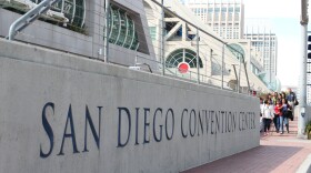 A group waits to cross Harbor Drive in front of the San Diego Convention Center. 