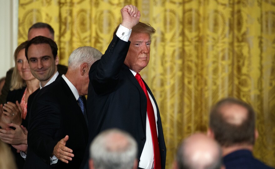 President Donald Trump pumps his fist as he leaves a meeting Monday in the East Room of the White House in Washington.