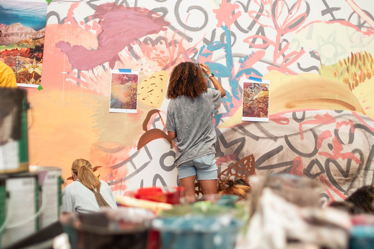 Students assist in painting a mural by artist Eva Struble at the San Diego Natural History Museum on Oct. 6, 2023.