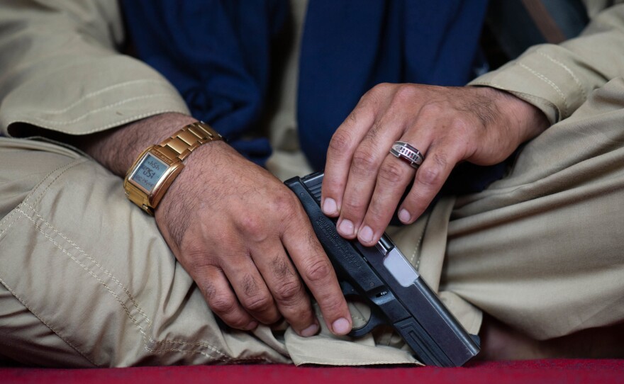 Wahadat holds a Smith & Wesson pistol.