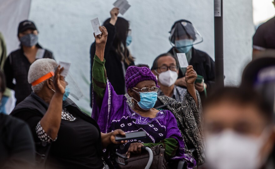 At a Kedren Community Health Center vaccine clinic in South Central Los Angeles this month, 89-year-old Cecilia Onwytalu (center) signals she's more than ready to get her immunization against COVID-19.