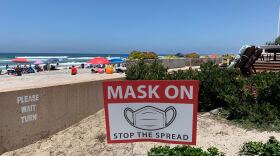 A sign requiring face covering is pictured at a beach in San Diego, July 10, 2020. 