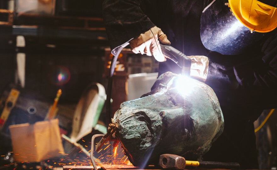 Workers hammer and slice off parts of the Robert E. Lee statue that stood in Charlottesville, Va. for decades. The city took it down in 2021 and donated the monument to a group working to transform it into a new piece of public art.