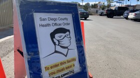 A sign notifies customers to wear a face covering at Coscto gas in Santee, Jan. 31, 2021.