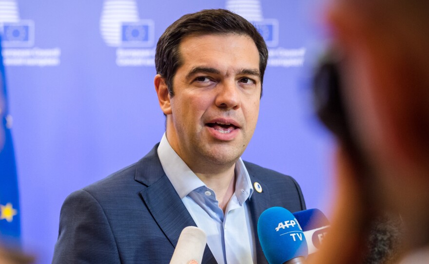 Greek Prime Minister Alexis Tsipras speaks with reporters after meeting with eurozone leaders in Brussels on Monday. The leaders reached a tentative agreement on a bailout program that provides cash in exchange for changes in the way the Greek government operates.