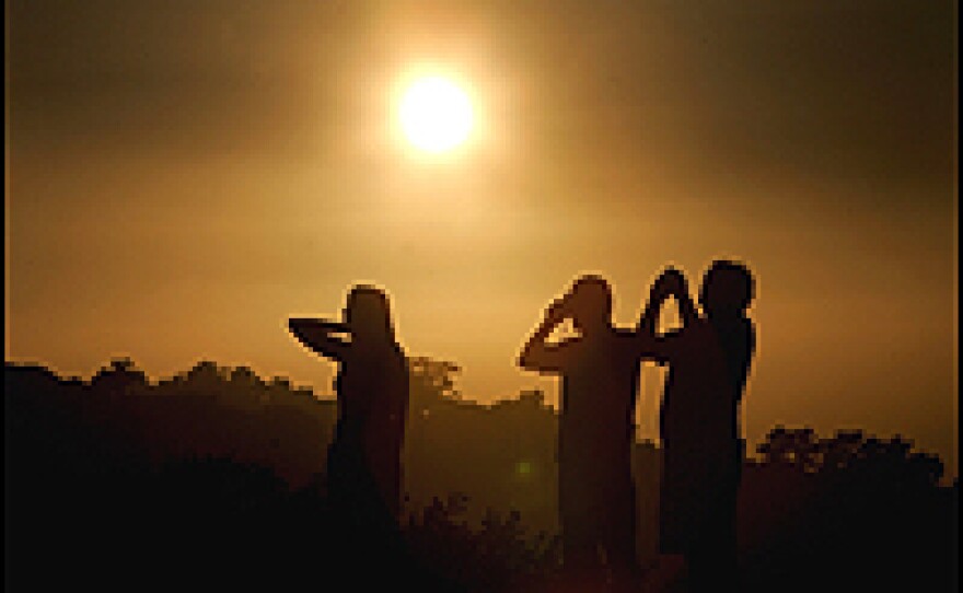 Tourists snap photos during a smoggy sunset in San Diego. California Gov. Arnold Schwarzenegger and Democratic leaders struck a deal calling for a 25 percent reduction in carbon-dioxide emissions in California by 2020.