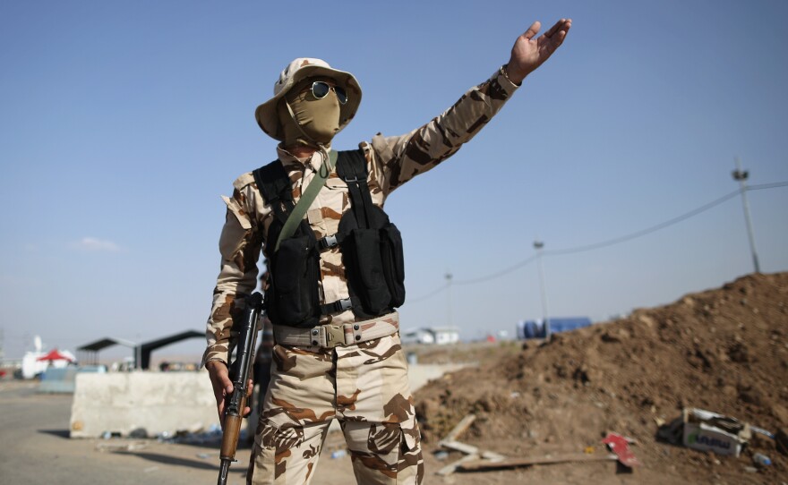 Peshmerga military direct traffic at a Kurdish Check point on Saturday in Kalak, Iraq. Thousands of people have fled Iraq's second city of Mosul after it was overrun by ISIS (Islamic State of Iraq and Syria) militants.